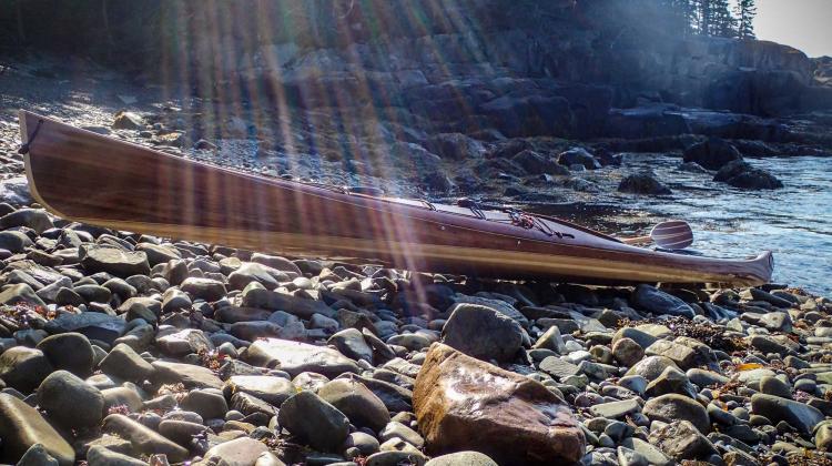 wooden sea kayak on rugged shore